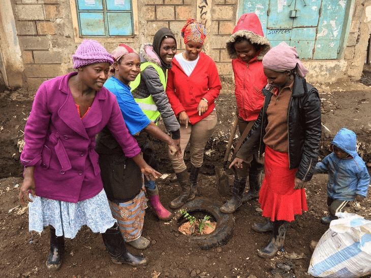 Image of women in Dandora successfully planting the first tree along the tree