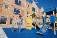Good quality accommodation - Statutory Temporary Accommodation (Cherry Tree View) - A resident and child enjoying the playground